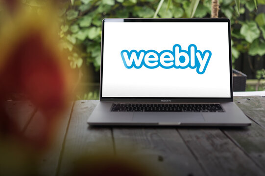 Weebly logo, an American web hosting and web development company offering WYSIWYG CMS system, displayed on a MacBook Pro screen