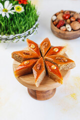 Traditional Azerbaijan holiday Novruz background with green semeni,traditional azerbaijan sweets,shekerbura,qogal,paxlava,mutaki and different nuts and sweets,top view,space for copy