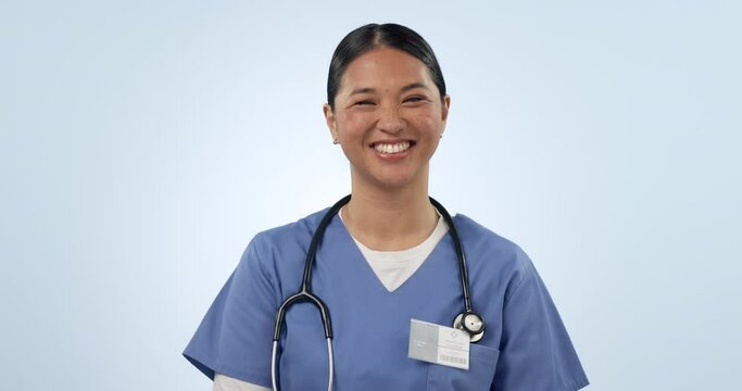 Woman, face and happy nurse in studio for healthcare services, surgery and commitment to medicine on blue background. Portrait, asian surgeon and expert medical doctor laughing with pride from Taiwan