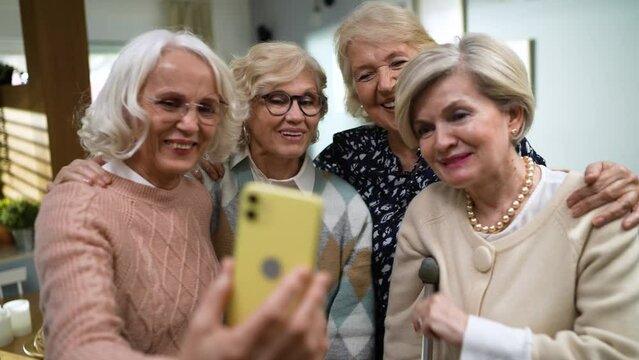 Group of senior female friends having a video call on the smartphone together at home