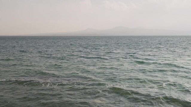 Slow motion Sevan lake low angle background with mountains on background