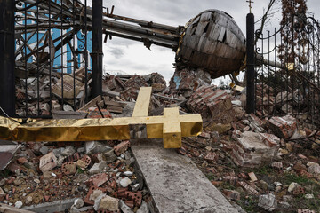 A fallen and broken cross from the church dome, and a destroyed cupola on the background....