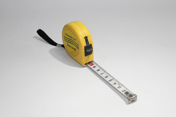 Yellow construction tape measure isolated on white background