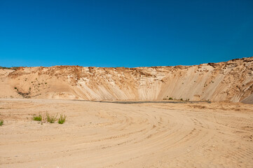 sand pit against the blue sky, forest in the background