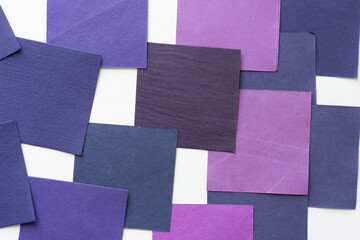 purple paper squares or tiles in various tones on white