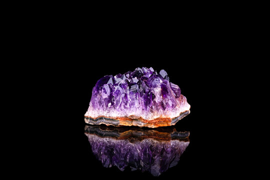 amethyst druse isolated on black background. macro detail close-up rough raw unpolished semi-precious gemstone.