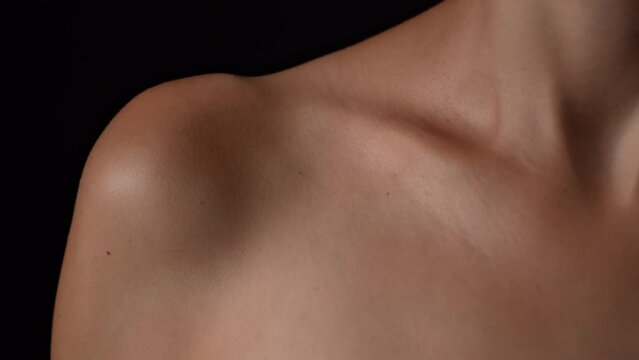 Portrait of an appealing caucasian female model. Closeup studio shot of young girl body part, collarbone shoulder and chest area.