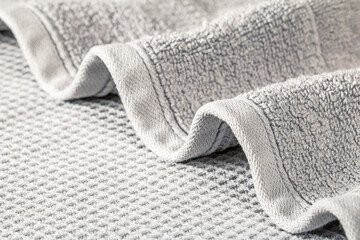 Soft terry towel folded in waves on a gray background close-up