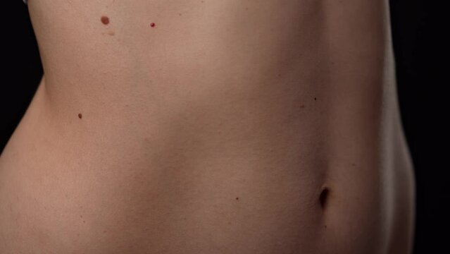 Closeup shot of beautiful caucasian woman body part, tummy and ribs area smooth skin, breathing deeply.