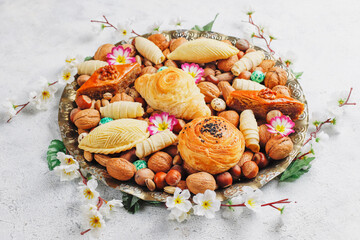 Fototapeta na wymiar Traditional Azerbaijan holiday Novruz background with green semeni,traditional azerbaijan sweets,shekerbura,qogal,paxlava,mutaki and different nuts and sweets,top view,space for copy