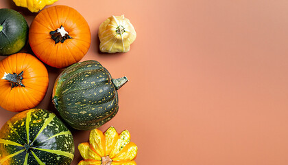 Different varieties of pumpkins on a simple orange background in flatlay style