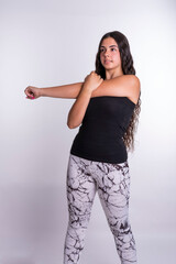 "Young Caucasian Woman Engaged in Muscle-Stretching Exercises Against a Clean White Background, Demonstrating Flexibility and Wellness."