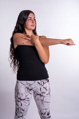 "Young Caucasian Woman Engaged in Muscle-Stretching Exercises Against a Clean White Background, Demonstrating Flexibility and Wellness."