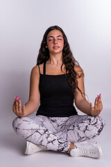 "Young Caucasian woman meditating on a white background with empty space on one side for writing."