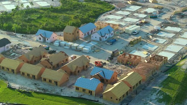 Aerial view of unfinished wooden frames of affordable houses under construction. Development of residential housing in american suburbs. Real estate market in the USA