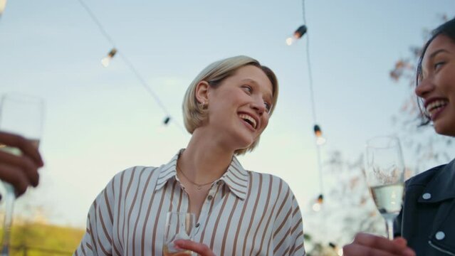 Carefree woman relaxing rooftop party closeup. Talking girl holding drink glass