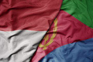 big waving realistic national colorful flag of indonesia and national flag of eritrea .