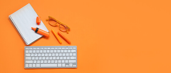 Notebook with eyeglasses, markers and computer keyword on orange background with space for text