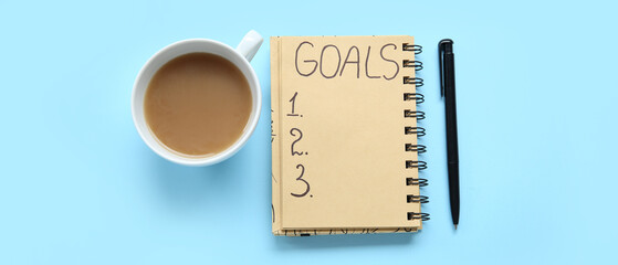 Notebook with empty to do list, pen and cup of coffee on light blue background. New year goals