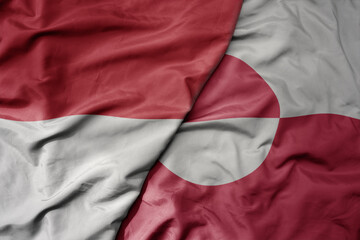 big waving realistic national colorful flag of indonesia and national flag of greenland .