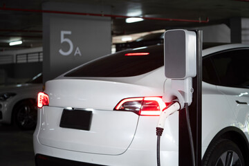 EV electric car recharge at shopping center parking lot charging in downtown city showing urban...