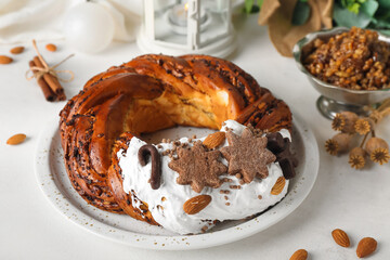 Plate with tasty Christmas pastry wreath and Kutya on light background