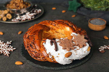 Board with delicious Christmas pastry wreath on dark background