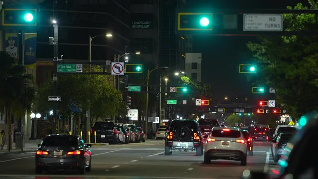 American wide multilane street intersection with traffic lights and moving cars at night. Transportation system in USA