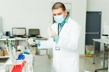 Hispanic chemist working in the medical lab using chemical agents
