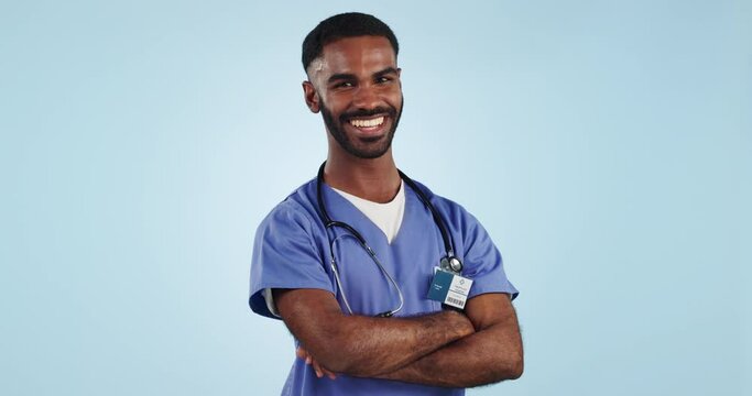 Doctor, face and man with smile or arms crossed in studio for confidence and pride in medicine and healthcare on blue background. Medical worker, person and professional in studio with stethoscope