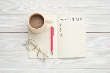 Notebook with empty to do list, eyeglasses and cup of coffee on white wooden background. New year goals