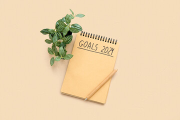 Notebook with empty to do list, pen and houseplant on beige background. New year goals