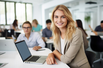 young businesswoman smiling while using her laptop in office