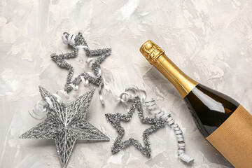 Christmas composition with bottle of champagne and decor on light background