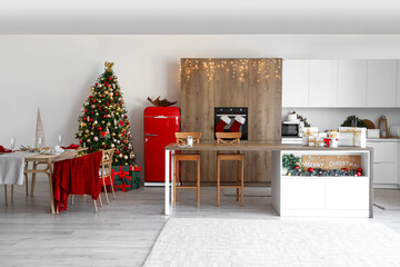 Interior of kitchen with glowing Christmas tree and dining table