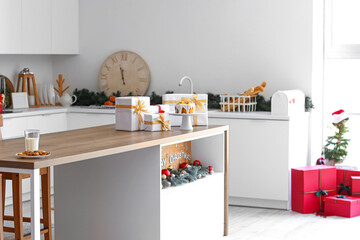 Christmas cake with presents on table in interior of kitchen