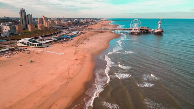 Sunset on the North Sea coast Scheveningen Pier and famous Ferris wheel SkyView de Pier, Den Haag, Netherlands. High quality 4k footage