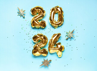 Golden foil balloons number 2024 and Christmas stars on blue background