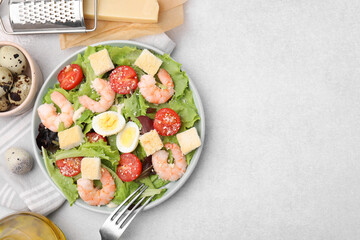 Delicious Caesar salad with shrimps and fork served on light table, flat lay. Space for text