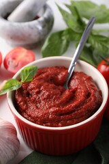 Tasty tomato paste in bowl on table, closeup