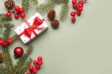 Christmas tree branches with gift box, ball and rowan on grey background