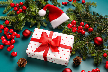 Fototapeta na wymiar Christmas tree branches with gift box, balls and rowan on blue background