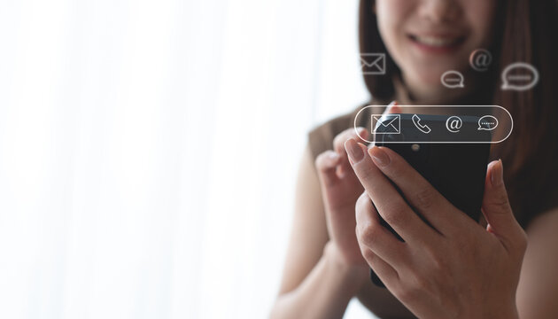 Contact us or Customer support, help center, people connect. Happy woman customer using mobile phone touching on virtual screen contact icons email, address, live chat, mobile phone via mobile app