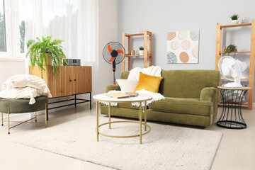 Obraz premium Interior of stylish living room with electric fans and sofa