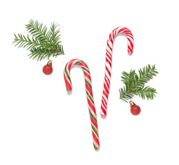 Candy canes, fir branches and Christmas balls on white background