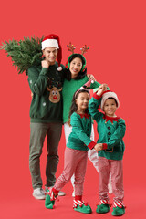 Happy family with Christmas tree on red background