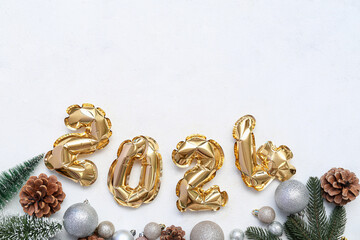 Composition with figure 2024 made of foil balloons and Christmas decorations on white background