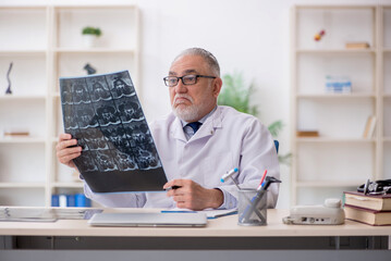 Old male doctor radiologist working in the clinic