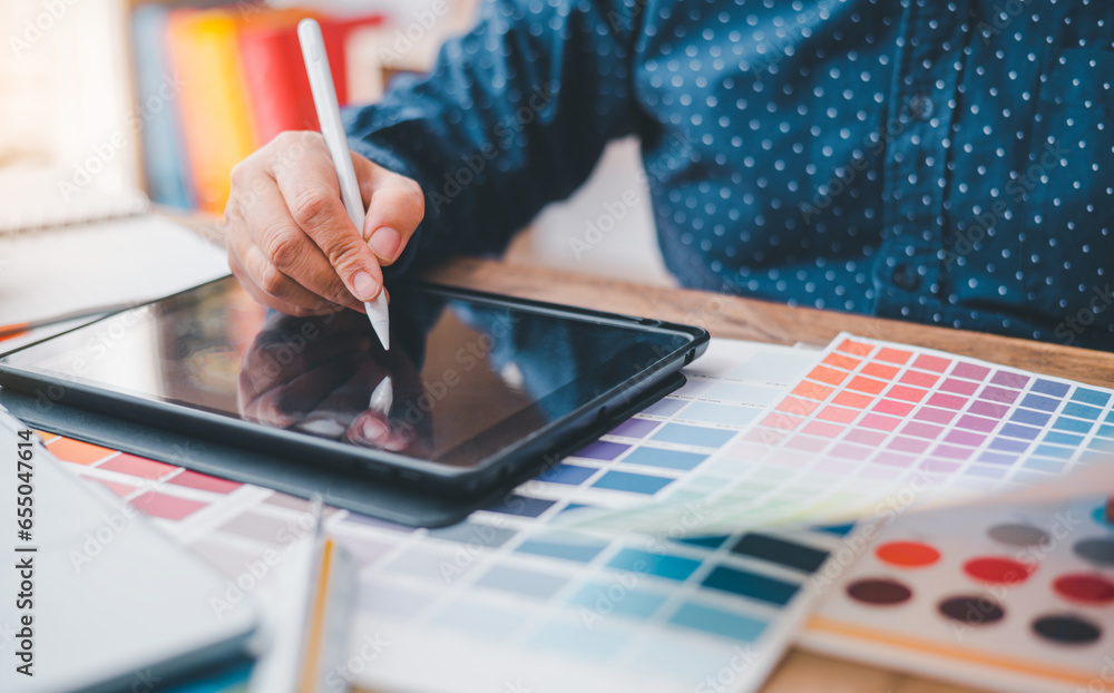 Poster graphic designer architects who work with laptops and color comparison tables for design work..
