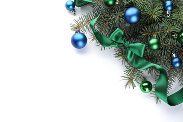 Fir branches with colorful Christmas balls and bow on white background
